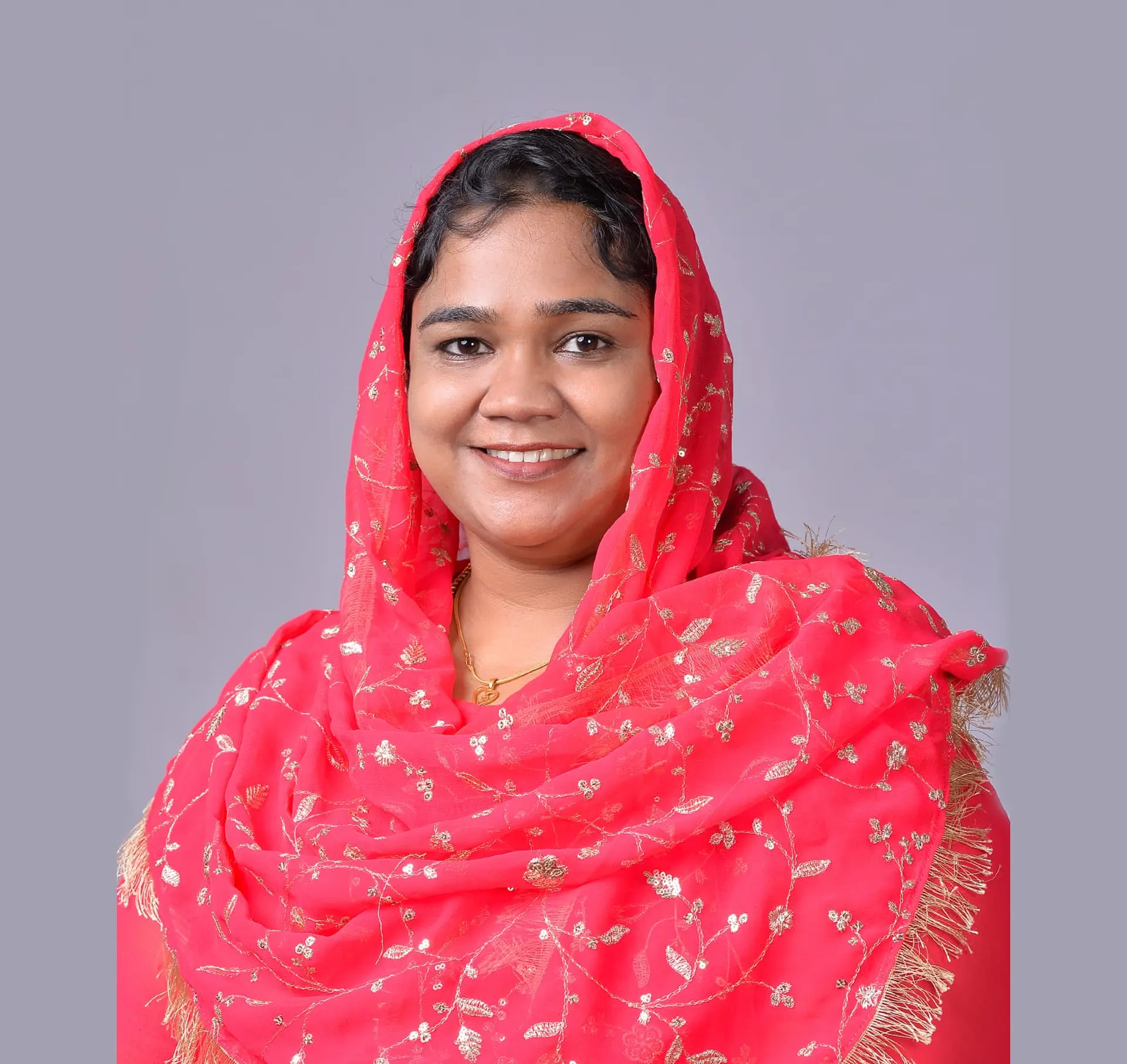 Ms. Barkath Nisha smiling while standing in front of the reception desk and the Havisha Hospital logo sign